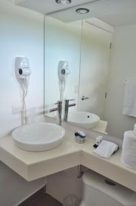 Baño blanco con lavabo y espejo en 中国人之家公寓酒店Apart-Hotel Casa de China, en Managua