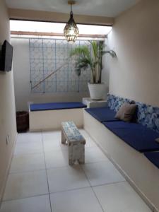 una sala de estar con sofás azules y un banco en La Estacion Hostel - Pipa, en Pipa