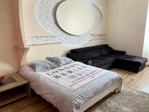 1 dormitorio con cama, espejo y sofá en Splendide Studio au cœur historique de Fréjus, en Fréjus