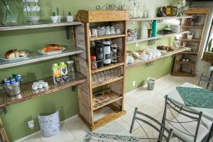 a room with a table and shelves with food at Hotel Pedra Bonita in Camaquã