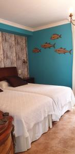 sypialnia z białym łóżkiem i niebieską ścianą w obiekcie Hotel Iris La Eliana w mieście La Eliana