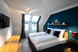 sypialnia z dużym łóżkiem i niebieską ścianą w obiekcie Boutique Design-Apartments Vienna w Wiedniu
