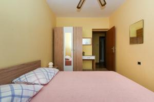 - une chambre avec un lit doté d'un couvre-lit rose dans l'établissement Apartments Kolt - 15m from sea, à Kali