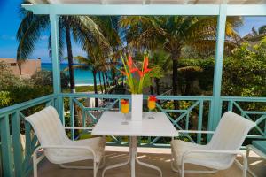 einen weißen Tisch und Stühle auf einem Balkon mit Meerblick in der Unterkunft Inchcape Seaside Villas in Christchurch