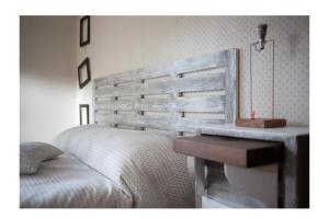 um quarto com uma cama e uma cabeceira em madeira em MeraVilla em Ascoli Piceno
