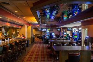 a restaurant with tables and chairs and televisions at Heritage Inn in Great Falls