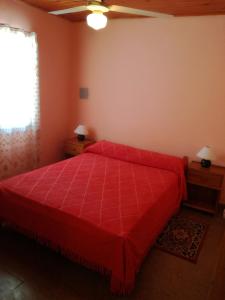 - une chambre avec un lit rouge et une fenêtre dans l'établissement Casa Marian, à Federación