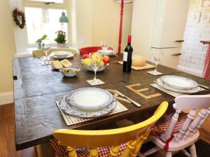 una mesa de madera con platos y copas de vino. en Weardale Cottage, en Saint Johns Chapel
