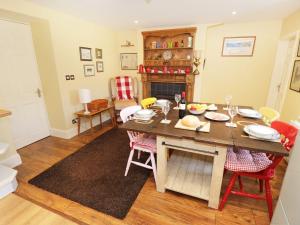 - un salon avec une table, des chaises et une cheminée dans l'établissement Weardale Cottage, à Saint Johns Chapel