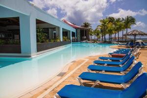 een zwembad met ligstoelen in een resort bij Studio kassav in Saint-François