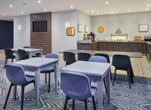 a waiting room with tables and chairs and a counter at Holiday Inn Express Grimsby by IHG in Grimsby +21 photos