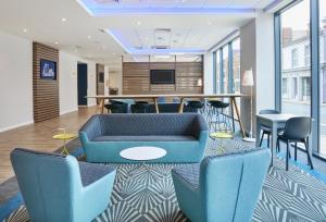 Holiday Inn Express Grimsby, an IHG Hotel في غريمسبي: لوبي مكتب وكراسي زرقاء وطاولة