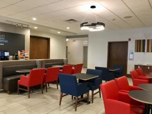 a waiting room with tables and red chairs at Holiday Inn Express - Grand Island by IHG in Niagara Falls