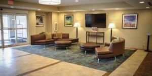 a lobby with couches and chairs and a flat screen tv at Candlewood Suites Pearl, an IHG Hotel in Pearl