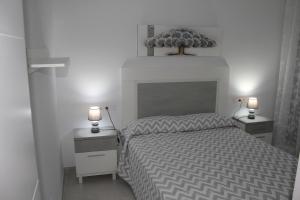 um quarto com uma cama com duas mesas de cabeceira e dois candeeiros em Apartamento Iceberg Tarifa Parking gratuito em Tarifa