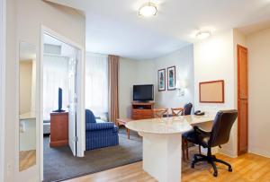 una sala de estar con mesa y sillas y una habitación en Candlewood Suites Jacksonville, an IHG Hotel en Jacksonville