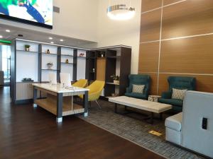 a waiting room with a table and yellow chairs at Holiday Inn - Jonesboro, an IHG Hotel in Jonesboro