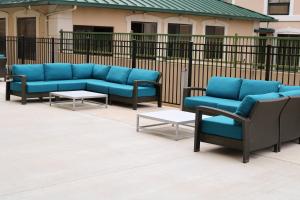 un gruppo di divani e tavoli blu di fronte a una recinzione di Holiday Inn - Jonesboro, an IHG Hotel a Jonesboro