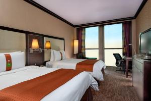 A bed or beds in a room at Holiday Inn Kuwait Al Thuraya City, an IHG Hotel