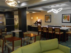 a waiting room with a couch and tables and chairs at Holiday Inn Express & Suites Houston Northwest-Brookhollow, an IHG Hotel in Houston