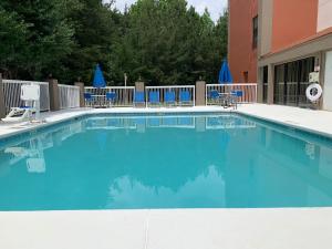 una piscina con sedie blu e un edificio di Holiday Inn Express Hillsborough-Durham Area, an IHG Hotel a Hillsborough
