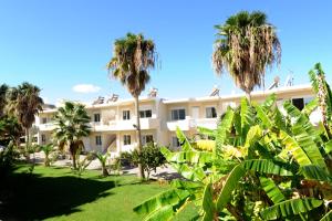 a building with palm trees in front of it at Evilion hotel in Stalos