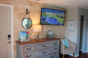 a room with a dresser and a mirror on a wall at Latitude 26 Waterfront Boutique Resort - Bonita Springs in Bonita Springs
