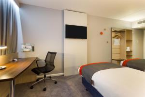a hotel room with a bed and a desk and a computer at Holiday Inn Express London - Watford Junction, an IHG Hotel in Watford