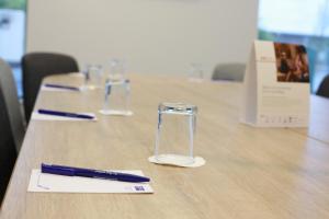 a table with two glasses and a pen on it at Holiday Inn Express - Manchester - TRAFFORDCITY, an IHG Hotel in Manchester