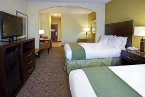 WallerにあるHoliday Inn Express Hotel & Suites Waller, an IHG Hotelのベッド2台、薄型テレビが備わるホテルルームです。