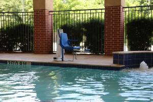 a blue chair sitting next to a swimming pool at Holiday Inn Express & Suites Deer Park, an IHG Hotel in Deer Park
