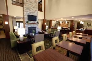 um restaurante com mesas e cadeiras e uma lareira em Staybridge Suites - Johnson City, an IHG Hotel em Johnson City