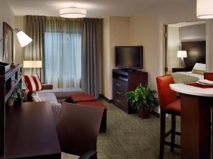 Habitación de hotel con sala de estar con cama y TV. en Staybridge Suites - Johnson City, an IHG Hotel, en Johnson City