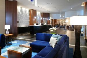 un soggiorno con divano blu e bar di ANA Crowne Plaza Kumamoto New Sky, an IHG Hotel a Kumamoto