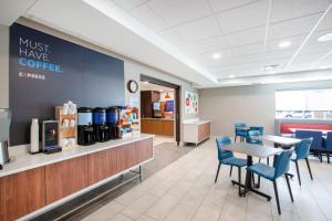 un restaurant avec des tables, des chaises bleues et un comptoir dans l'établissement Holiday Inn Express Hastings by IHG, à Hastings