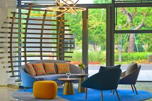 a living room with a couch and chairs and a spiral staircase at Holiday Inn Express Hangzhou Binjiang, an IHG Hotel in Hangzhou