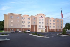 ein großes Gebäude mit Autos auf einem Parkplatz in der Unterkunft Candlewood Suites North Little Rock, an IHG Hotel in North Little Rock