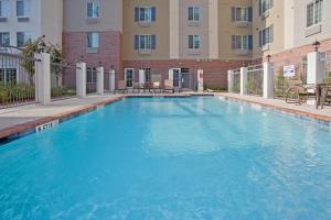 a large swimming pool in front of a building at Candlewood Suites Houston The Woodlands, an IHG Hotel in The Woodlands
