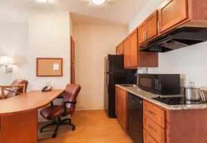 a kitchen with a table and a black refrigerator at Candlewood Suites Georgetown, an IHG Hotel in Georgetown