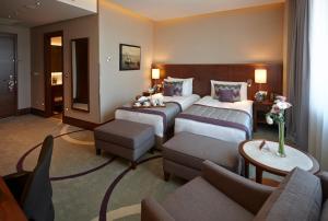a hotel room with two beds and a couch at Crowne Plaza Istanbul Oryapark by IHG in Istanbul