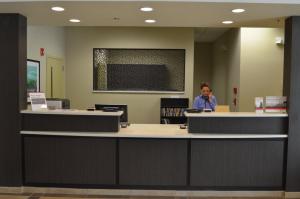 a man standing at a counter in a library at Candlewood Suites Harlingen by IHG in Harlingen
