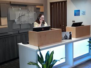 a woman talking on a cell phone at a reception desk at Holiday Inn Express Hotel Pittsburgh-North/Harmarville, an IHG Hotel in Harmarville