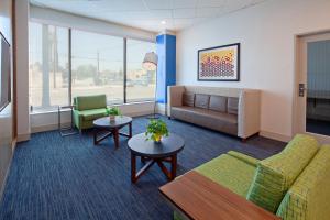 a waiting room with a couch and chairs and a table at Holiday Inn Express Los Angeles LAX Airport, an IHG Hotel in Los Angeles