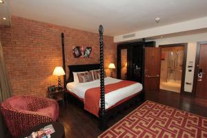 a bedroom with a bed and a dresser at Hotel Indigo London Tower Hill, an IHG Hotel in London