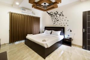 
a bedroom with a large bed and a large mirror at Crystal Lake Suites in Coimbatore
