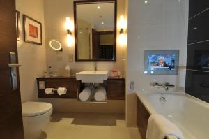 a bathroom with a toilet a sink and a mirror at Crowne Plaza London - Gatwick Airport, an IHG Hotel in Crawley