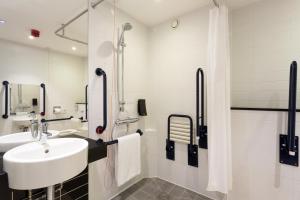 a white bathroom with a sink and a shower at Holiday Inn Express Harlow, an IHG Hotel in Harlow