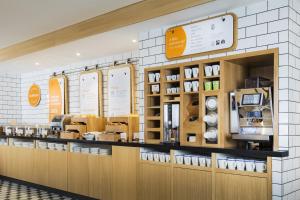 a store with a coffee shop with a counter at Holiday Inn Express Park Royal, an IHG Hotel in London