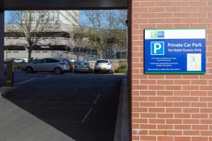 a parking sign on the side of a brick building at Holiday Inn Express Harlow, an IHG Hotel in Harlow