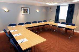 una sala de conferencias con mesas y sillas de madera en Knowsley Inn & Lounge formally Holiday Inn Express, en Knowsley